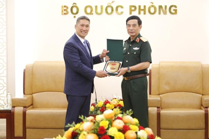 Đại tướng Phan Văn Giang trao quà lưu niệm tặng Quyền Bộ trưởng Bộ Hải quân Hoa Kỳ Hùng Cao tại buổi tiếp. Ảnh: BQP