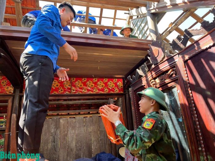 Cán bộ Đồn Biên phòng Làng Mô cùng các lực lượng tại địa phương giúp dân lợp nhà. Ảnh: Huy Hoàng