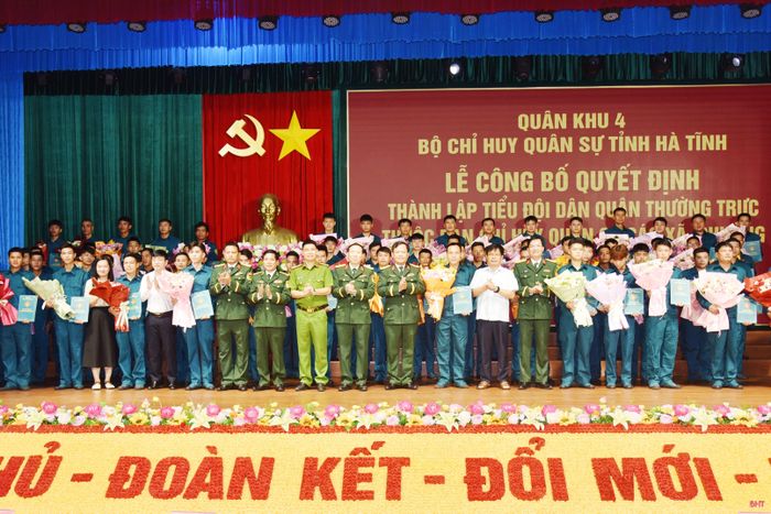 Lãnh đạo Bộ CHQS tỉnh và các sở, ngành tặng hoa chúc mừng các tiểu đội trưởng tiểu đội dân quân thường trực.