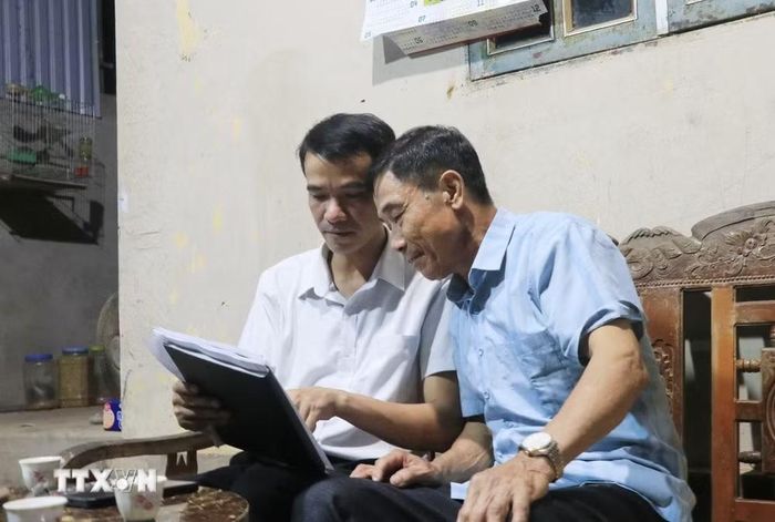 Cán bộ xã Việt Hồng (Lào Cai) đến từng hộ dân tuyên truyền và lấy ý kiến nhân dân về chủ trương sáp nhập thôn. (Ảnh: Anh Thùy/TTXVN)