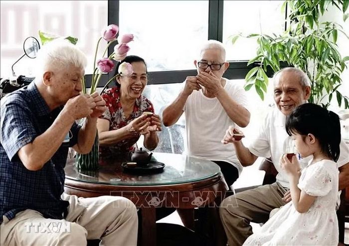 Hàn huyên bên những người bạn quý, thưởng thức hương vị tuyệt phẩm thơm đậm vị sen của chén trà từ lâu đã trở thành một điều đặc biệt của nguời Hà Nội. (Ảnh: Khánh Hòa/TTXVN)