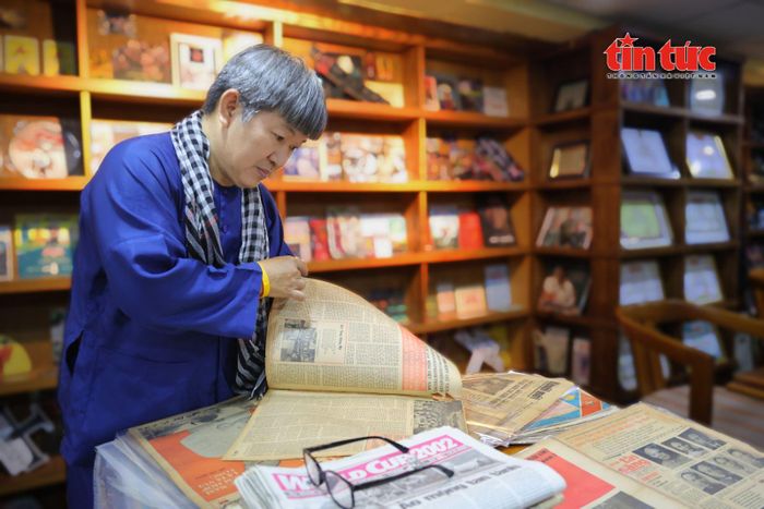 Ông Hiệp cẩn thận lật từng trang báo cũ trong bộ sưu tập tư liệu lịch sử của mình.