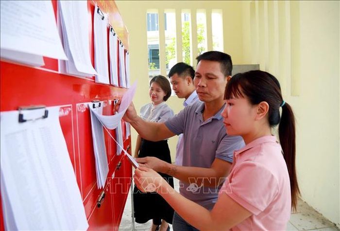 Người dân xã Tiên Tiến (Hưng Yên) xem danh sách cử tri và dự thảo Đề án sắp xếp lại thôn trên địa bàn.