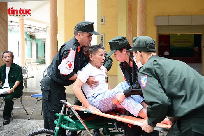 Các chiến sĩ quân y Bộ Tư lệnh Cảnh sát cơ động hỗ trợ thương, bệnh binh di chuyển tới khu vực khám bệnh.