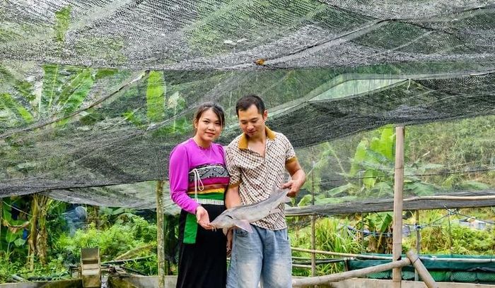 Vợ chồng chị Lương Thị Lực bên mô hình nuôi cá tầm giữa rừng sâu. Ảnh: Đình Giang