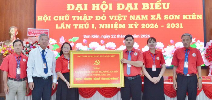 Bí thư Đảng ủy xã Sơn Kiên Phạm Thanh Hùng (thứ hai, từ trái qua) tặng bức trướng cho đại hội.