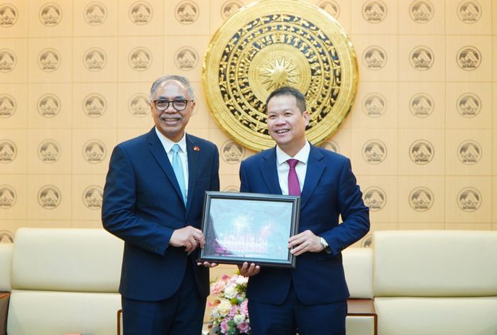 Chủ tịch UBND thành phố Nguyễn Mạnh Hùng trao quà lưu niệm cho Đại sứ Adam M. Tugio. Ảnh: VINH ANH