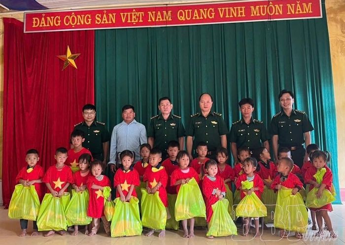 Trung úy Lỳ Phú Hừ và cán bộ, chiến sĩ Đồn Biên phòng Nà Bủng tặng quà các cháu thiếu nhi bản Nà Bủng 1.