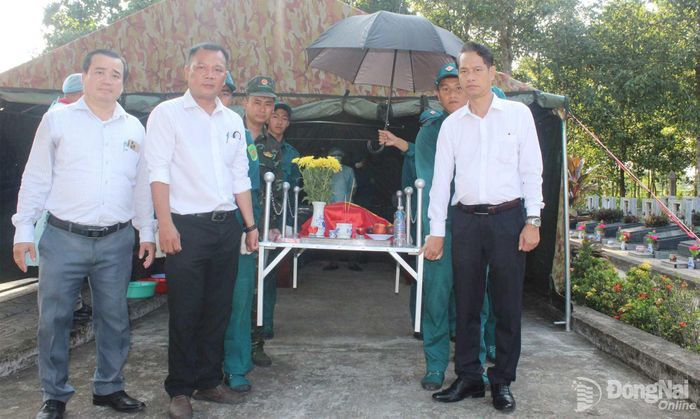 Thường trực Đảng ủy, HĐND, UBND, Ủy ban MTTQ xã Phước An thực hiện nghi thức di quách hài cốt liệt sĩ thực hiện lấy mẫu. Ảnh: Đoàn Mai