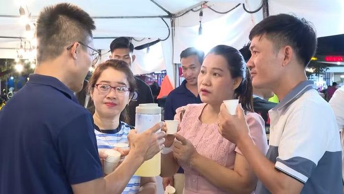 Người dân Campuchia thưởng thức và nghe giới thiệu về các sản phẩm nước uống thanh nhiệt mà tỉnh Gia Lai đem đến hội chợ triển lãm. Ảnh: R'Piên