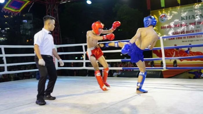 Màn ra đòn chân uy lực của võ sĩ Phan Hoàng Kỳ Phong (giáp xanh, xã Mang Yang) với võ sĩ Nguyễn Ngọc Anh Khôi (giáp đỏ, phường Quy Nhơn). Ảnh: H.V