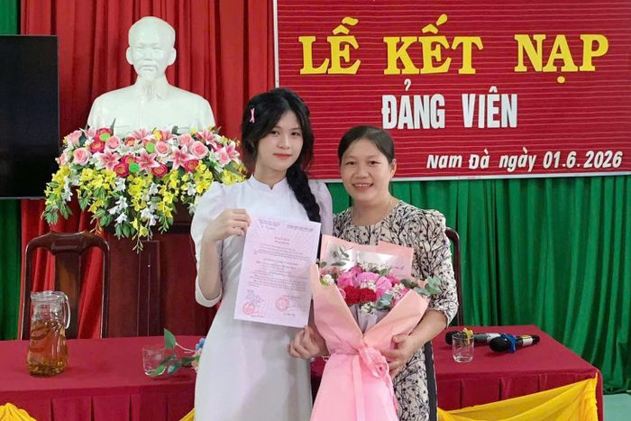 Em Lang Thị Thúy Hoài chụp ảnh lưu niệm với giáo viên chủ nhiệm khi được nhận Quyết định kết nạp Đảng