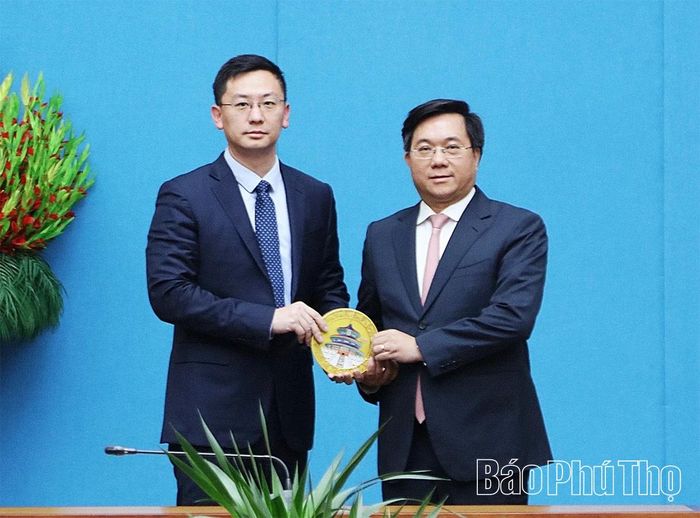 Ông Lý Huy - Ủy viên Ban Điều hành, Công ty Chứng khoán Quốc Tế Hải Thông tặng quà lưu niệm cho Chủ tịch UBND tỉnh Trần Duy Đông.