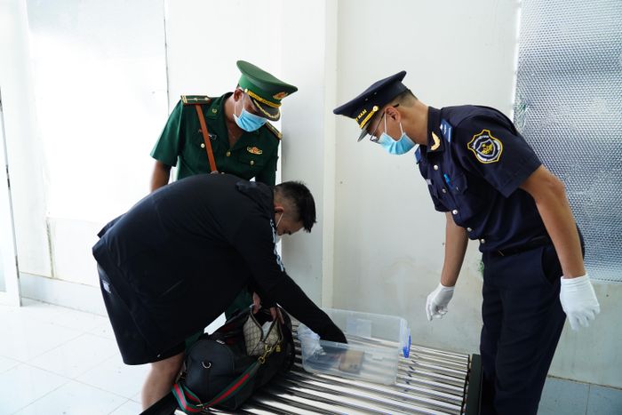 Cán bộ đồn trạm kiểm soát Biên phòng cửa khẩu Quốc tế Vĩnh Xương, phối hợp với Hải quan tiến hành soi chiếu hành lý du khách qua lại cửa khẩu. Ảnh: Tiến Vinh