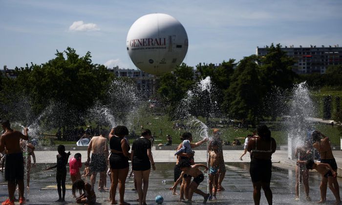 Người dân tắm vòi nước trong công viên để giải nhiệt ở Pháp - Ảnh: Reuters