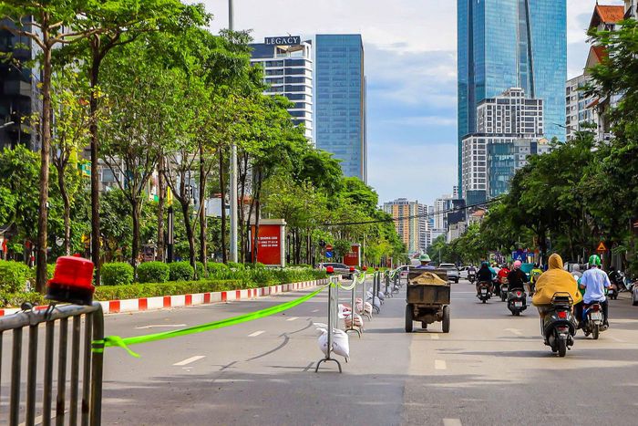 Tại vị trí xây dựng ga S1 - ga Quần Ngựa, đơn vị thi công thực hiện rào chắn cố định dải phân cách giữa và toàn bộ phần lòng đường phía sân vận động Quần Ngựa với chiều dài khoảng 476m, bề rộng từ 20m đến 40m. Một phần lòng đường Văn Cao ở cả hai chiều lưu thông cũng được điều chỉnh để phục vụ thi công nhà ga ngầm. Ảnh: Duy Khánh