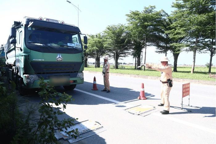 Lực lượng cảnh sát giao thông kiểm tra tải trọng phương tiện có dấu hiệu vi phạm. Ảnh: PV
