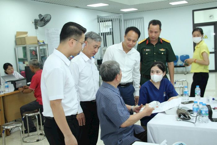 Lãnh đạo phường Phú Thượng cùng cán bộ Trạm Y tế phường thăm hỏi, động viên người có công. Ảnh: Hoàng Vũ