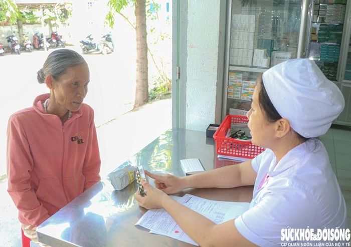 Nhân viên y tế Trạm Y tế phường Ba Ngòi cấp phát thuốc và hướng dẫn sử dụng thuốc cho bà Mấu Thị Nhím. Ảnh: Duy Ngọc.
