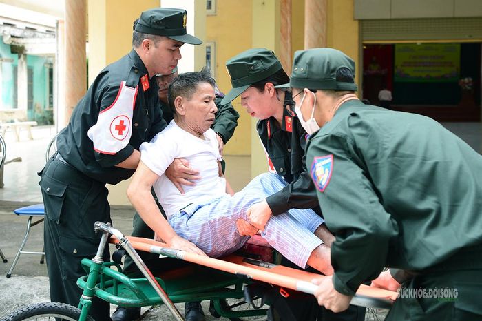 Các chiến sĩ hỗ trợ đưa thương binh lên cáng để thăm khám.