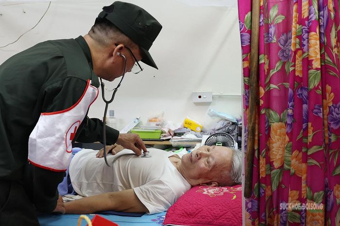 Bác sĩ quân y thăm khám tại giường cho thương binh sức khỏe yếu.