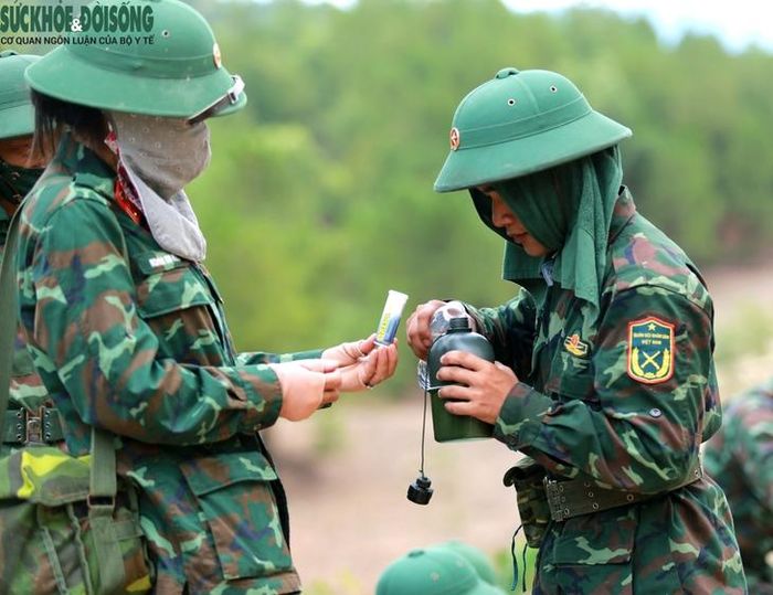 Trung tá, y sĩ Nguyễn Thị Hồng, Lữ đoàn Công binh 414 chuẩn bị Oresol cho cán bộ, chiến sĩ làm nhiệm vụ chữa cháy rừng tại xã Thiên Nhẫn nhằm phòng chống mất nước, kiệt sức do nắng nóng.