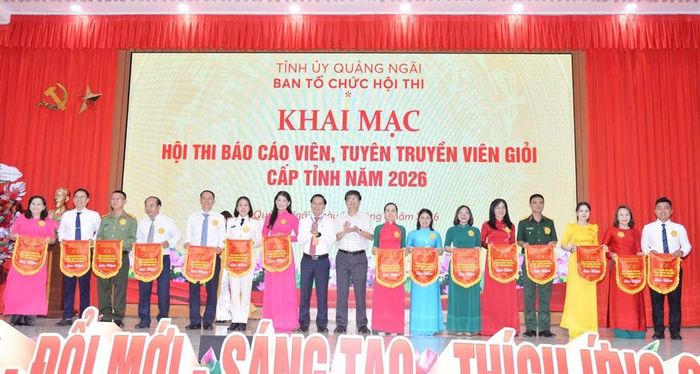 Các thí sinh nhận cờ lưu niệm từ Ban Tổ chức tại lễ khai mạc vòng chung khảo Hội thi Báo cáo viên, Tuyên truyền viên giỏi cấp tỉnh năm 2026