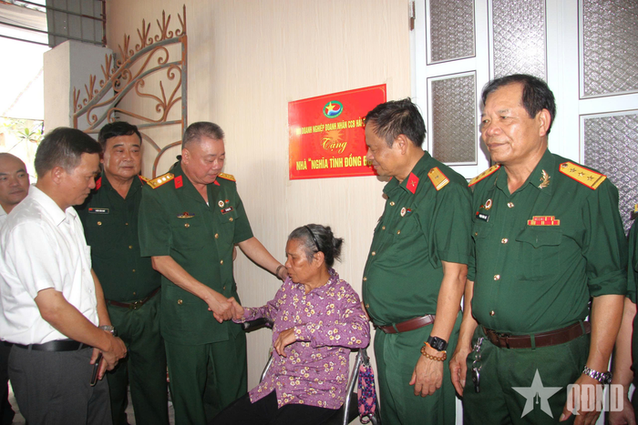 Các đại biểu thăm hỏi, chúc mừng bà Mai Thị Ngát trong ngôi nhà mới được sửa chữa.
