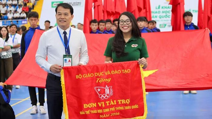 Đại diện Bộ GD&ĐT trao cờ cho đơn vị tài trợ.
