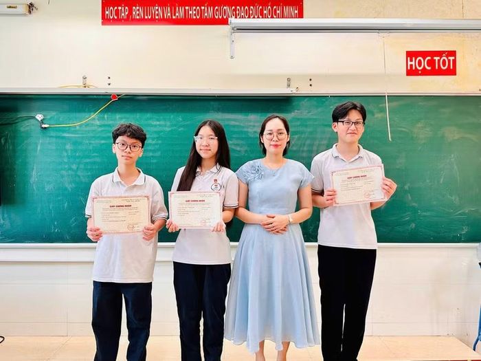 Nguyễn Đức Minh (bên trái) và các bạn chụp cùng cô giáo chủ nhiệm Phạm Phương Thanh.