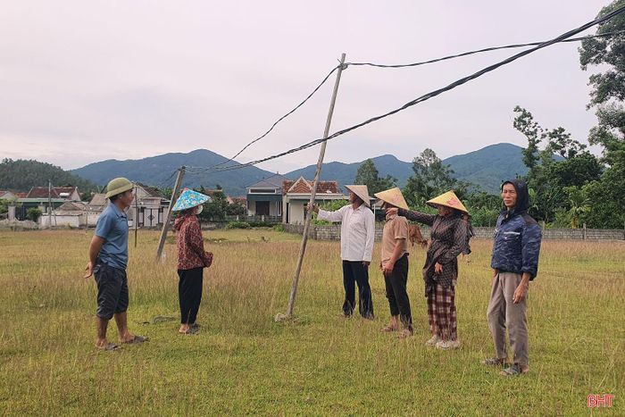 Ông Hồ Phúc Lâm (áo trắng) - Trưởng thôn Cứu Quốc cùng người dân phản ánh việc kéo điện bằng cọc tre, gỗ tạm bợ rất nguy hiểm với người dân và gia súc.