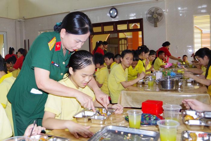 Tận tình hướng dẫn, hỗ trợ các cháu khuyết tật vận động sử dụng đũa, thìa để ăn cơm.