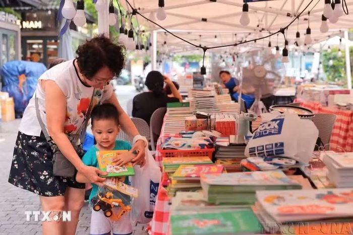 Niềm vui của trẻ khi được bà đưa đi mua sách và những món đồ chơi yêu thích. (Ảnh: Hoàng Hiếu/TTXVN)
