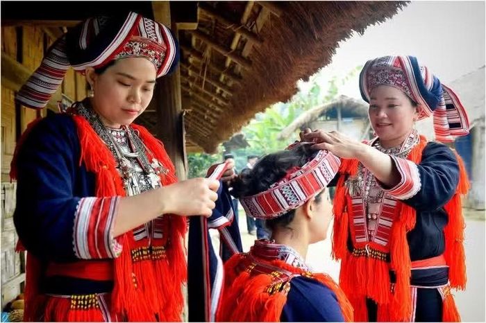 Phụ nữ dân tộc Dao diện trang phục sặc sỡ chuẩn bị cho Ngày hội Gia đình tại Làng Văn hóa Du lịch các Dân tộc Việt Nam. (Ảnh: vinaculto.vn)