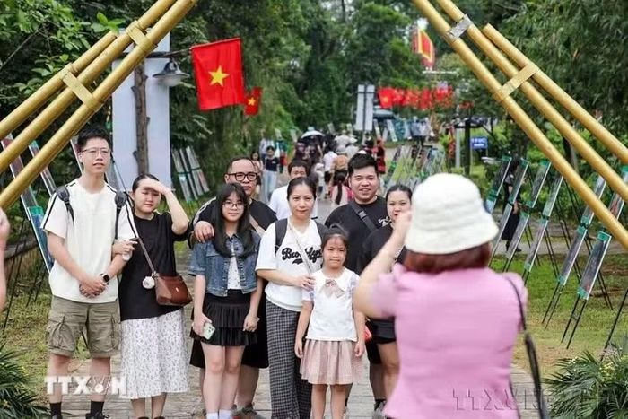 Các gia đình lưu lại khoảnh khắc tại Làng Văn hóa Du lịch các Dân tộc Việt Nam. (Ảnh: Khánh Hòa/TTXVN)