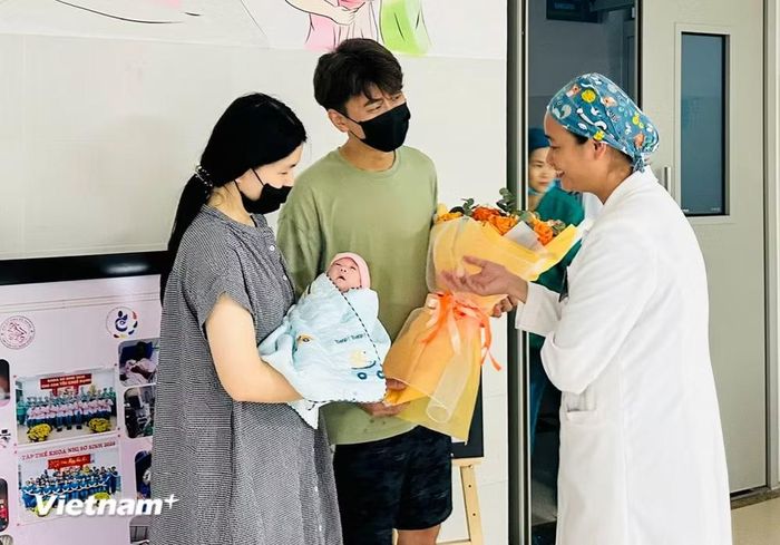 Đội ngũ y, bác sỹ bệnh viện Phụ sản - Nhi chúc mừng gia đình du khách. (Ảnh: PV/Vietnam+)