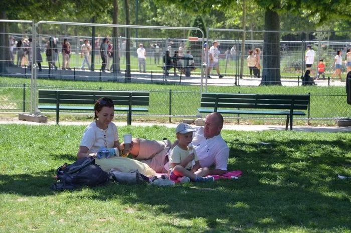 Một gia đình tránh nóng dưới bóng mát trong một công viên ở thủ đô Paris. (Ảnh: Hữu Chiến/TTXVN)