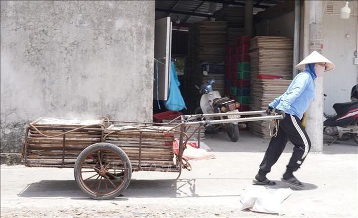 Giữa cái nắng như đổ lửa, người dân vẫn cần mẫn kéo từng xe cá hấp ra phơi.