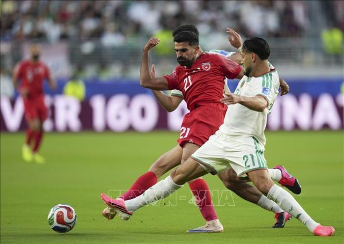 Pha tranh bóng giữa tiền vệ Jordan Nizar Alrashdan (trái) và hậu vệ Algeria Ramy Bensebaini. Ảnh: THX/TTXVN