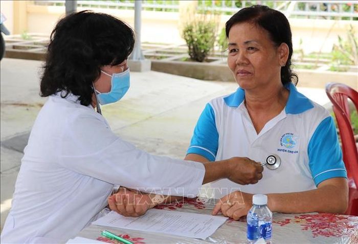 Bác sĩ khám bệnh cho người dân đến khám sàng lọc miễn phí.