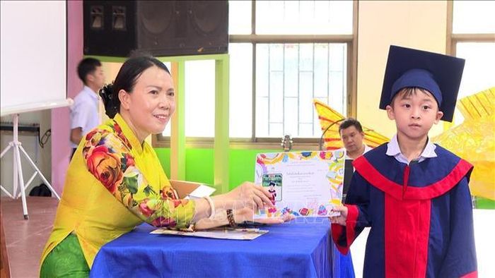Hiệu trưởng Nguyễn Thị Thanh Hương trao bằng tốt nghiệp cho học sinh lớp mẫu giáo 3. Ảnh: Xuân Tú/PV TTXVN tại Lào