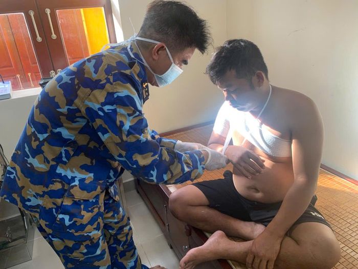 Quân y nhà giàn băng bó, cố định khớp vai phải cho ngư dân. Ảnh: Văn Đường