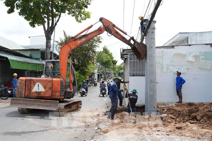 Triển khai di dời hệ thống hạ tầng kỹ thuật như điện và viễn thông, tạo điều kiện thuận lợi để đẩy nhanh tiến độ thi công. Ảnh: Công Trí-TTXVN