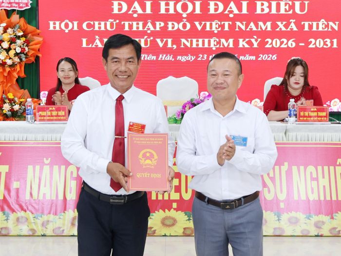 Phó Chủ tịch UBND xã Tiên Hải Tiền Kim Hên (bìa phải) trao quyết định của UBND xã cho phép tổ chức lại Hội Chữ thập đỏ xã.