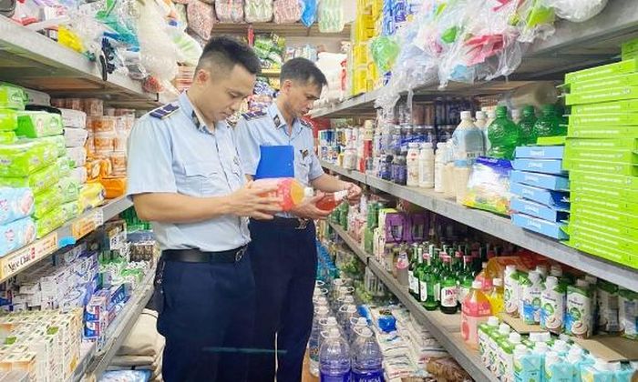 Cán bộ quản lý thị trường kiểm tra tem, nhãn các loại nước giải khát đóng chai tại cửa hàng Hải Hà, chợ Vĩnh Ninh (phường Bắc Giang).