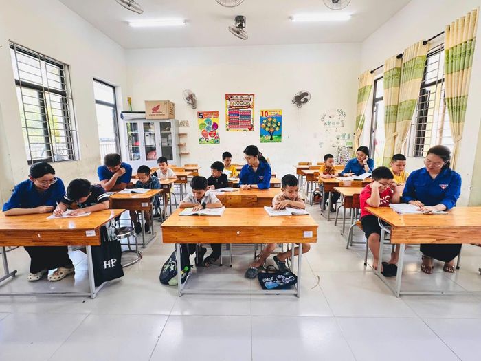 Giáo viên và tình nguyện viên hỗ trợ kiến thức cho các em học sinh tham gia lớp học “Hoa phượng đỏ”. Ảnh: H.V