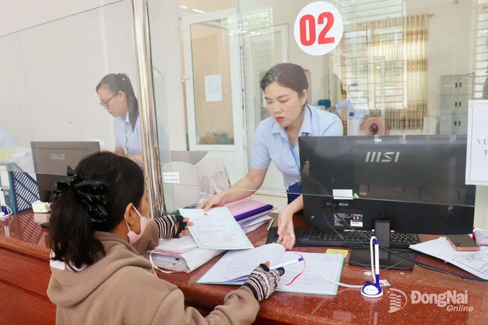 Cán bộ Trung tâm Phục vụ hành chính công xã Phú Nghĩa hướng dẫn người dân thực hiện thủ tục hành chính. Ảnh: Hải Yến