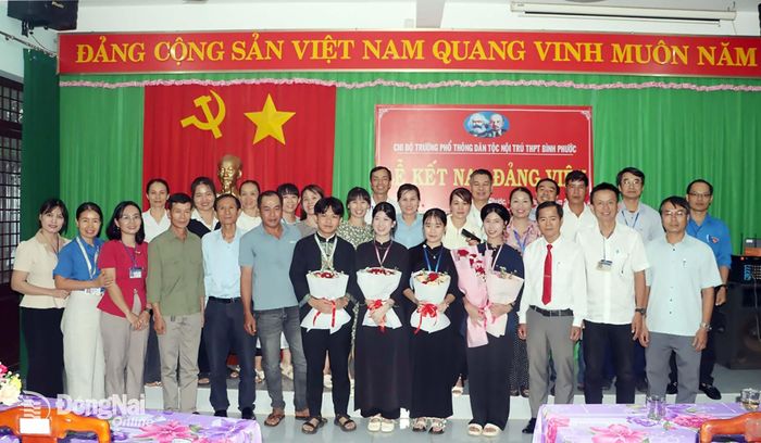 Chi bộ Trường Phổ thông dân tộc nội trú THPT Bình Phước và các đại biểu chụp hình lưu niệm với 4 đảng viên trẻ là học sinh tại lễ kết nạp Đảng. Ảnh: Vũ Thuyên
