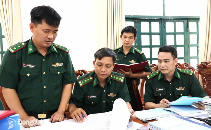 Thượng tá Nguyễn Xuân Hải, Trợ lý Tuyên huấn, Cục Chính trị (thứ 2, từ trái qua) và Trung tá Đặng Ngọc Hưng, Trợ lý Quân huấn - Nhà trường, Bộ Tham mưu Bộ đội Biên Phòng kiểm tra hồ sơ liên quan việc thực hiện Quy chế dân chủ cơ sở tại Đồn Biên phòng Cửa khẩu quốc tế Hoa Lư. Ảnh: Nguyệt Hà