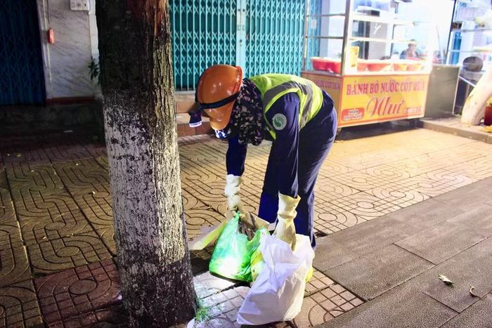  Chị Hồng cẩn thận thu gom rác trên tuyến đường Cách Mạng Tháng Tám (phường Pleiku). Ảnh: Minh Chí 